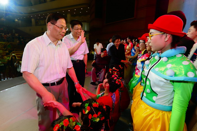 图为中残联领导、北京市领导与演员们亲切握手