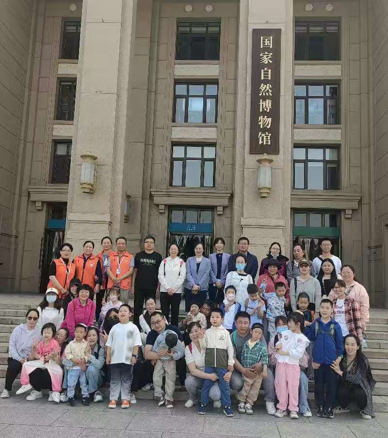 图为参加活动儿童与国家自然博物馆工作人员、志愿者合影