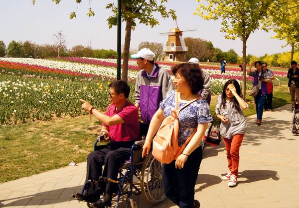 图为重残人在志愿者的照顾下观赏鲜花