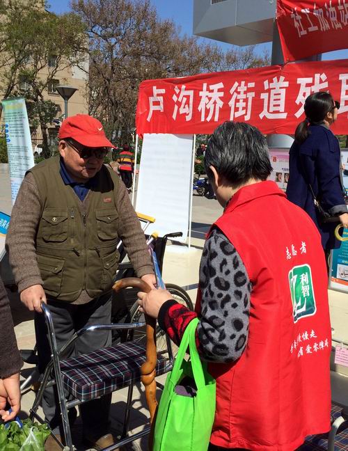 图为社区居民在志愿者指导下体验辅具