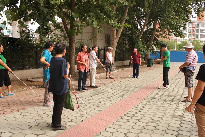 图为老师指导盲人定向行走训练