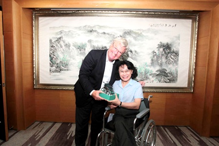图为海迪主席向彼得·克里夫赠送亲自设计的轮椅模型