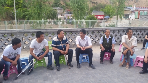 图为鲁勇一行在延川县与残疾人贫困户、残疾人致富带头人和乡镇干部座谈