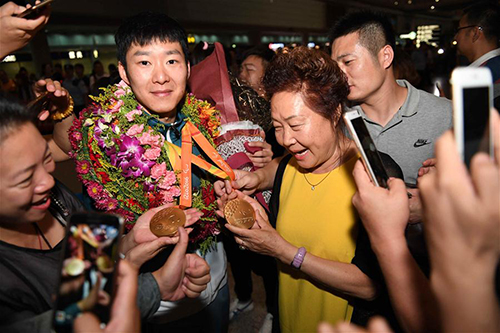 9月20日，接机群众与里约残奥会男子乒乓球冠军葛杨（左二）合影。当日，里约残奥会中国代表团抵达北京首都国际机场，受到接机群众的热烈欢迎。 新华社记者贺长山摄