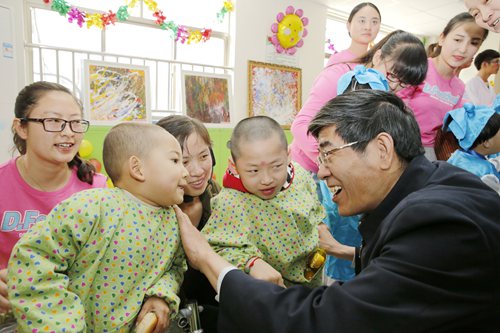 图为鲁勇与自治区残疾人康复中心的孩子们亲切交谈