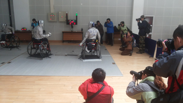 图为摄影爱好者拍摄轮椅击剑运动员训练