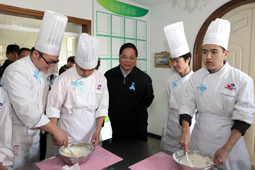 中国残联党组书记、理事长王新宪看望参加烘焙技能培训的大龄孤独症孩子