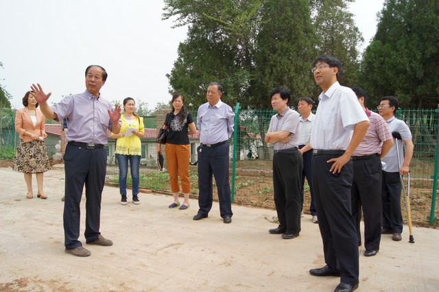 图为市残联调研组一行实地查勘公园建设场地