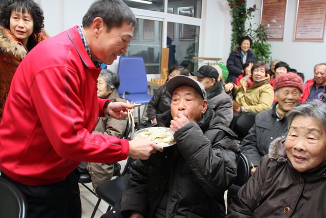 图为残疾学员为老人端饺子