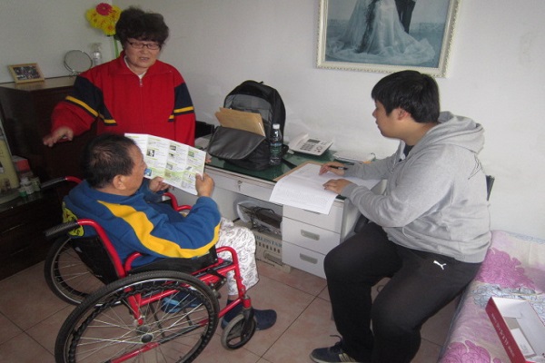 图为工作人员对残疾人家庭进行无障碍改造评估