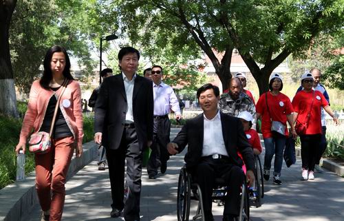 图为市区残联领导携手残疾人开展了“心手相牵，为爱行走活动”