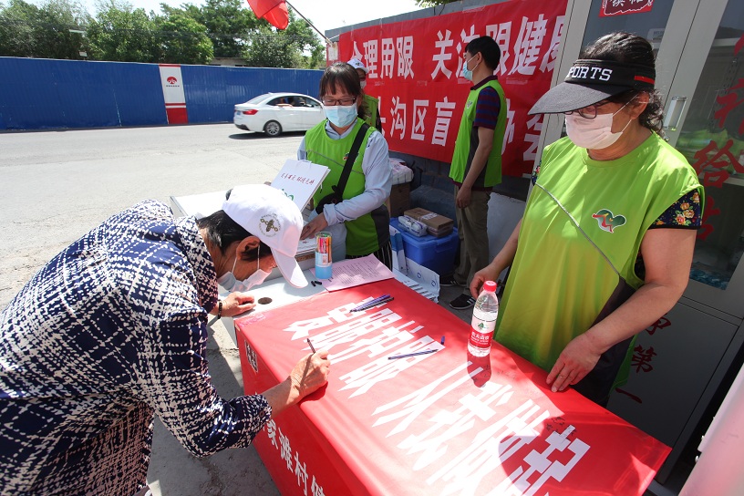 图为居民在宣传横幅上签名