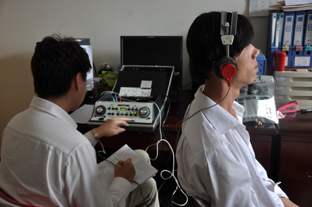 图为:专业人员为残疾人进行听力测试