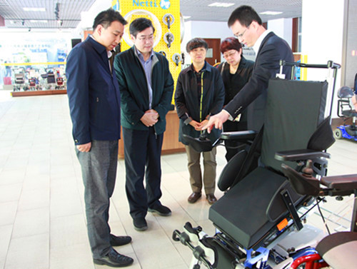 图为李晞主任参观可站立式电动轮椅