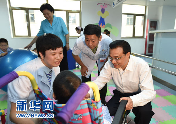 这是李克强与康复中的患儿交谈。 新华社记者马占成摄