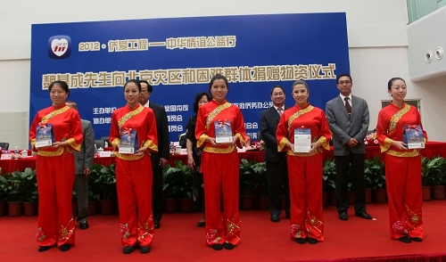 图为：捐赠人向听障残疾人代表捐赠助听器